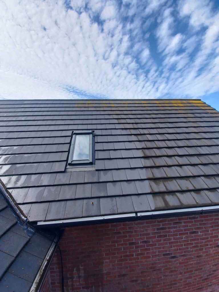 cleaning roof tiles on a house
